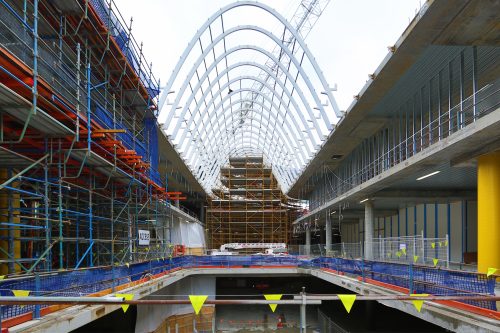 An arch of steel beams lining the roof of a shopping centre.
