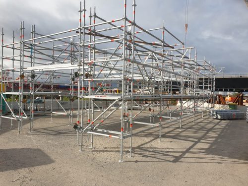 Freestanding modular Layher scaffold bays assembled in an open yard