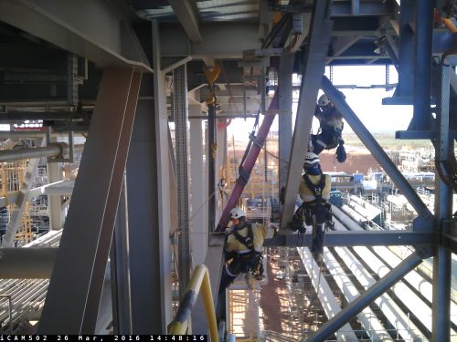 3 APS technicians suspended by rope doing work on scaffolding
